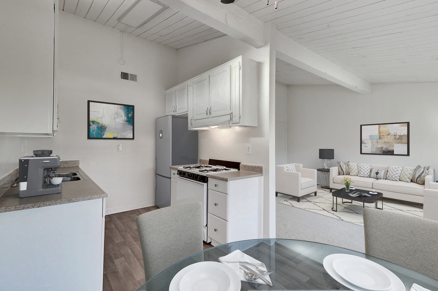 a kitchen and living room with a glass table